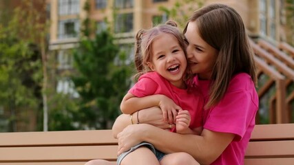 a child and his mother are talking on a park bench in the summer, having fun together, a happy childhood, mom and daughter - Powered by Adobe