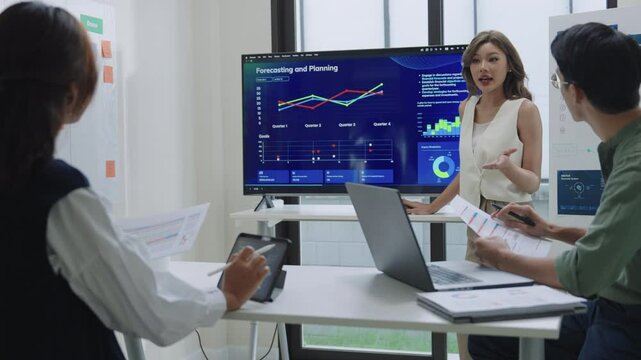 financial investor asking question when leader reviewing data during a nighttime meeting financial projections and digital reports displayed on a screen