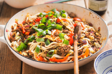 Asian stir fry with spicy beef, noodles, red pepper, cabbage, red onion 