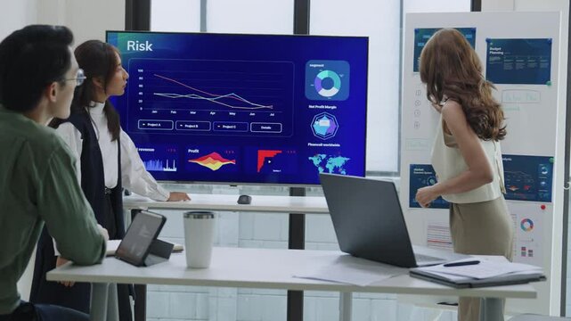 asian leader presenting a financial data and strategies in a modern office with charts and graphs displayed on a large screen