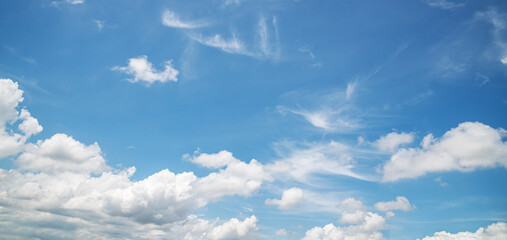 Bright blue sky with fluffy white clouds on sunny day
