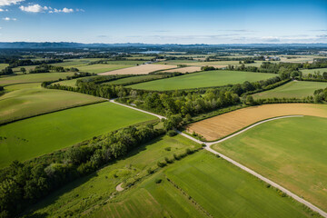 High-Angle Shot of a Peaceful Rural Town with Green Fields and Blue Sky