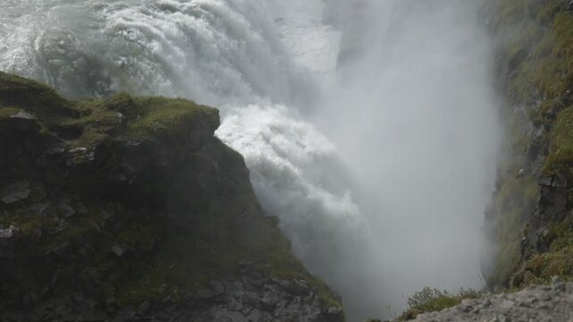 Slow Motion. A high angle view of a powerful waterfall streaming down a mountain in Iceland. 