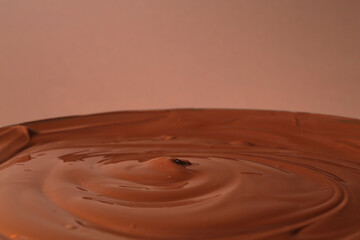 Delicious melted chocolate on brown background, closeup