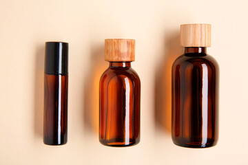 Essential oils in bottles on beige background, flat lay