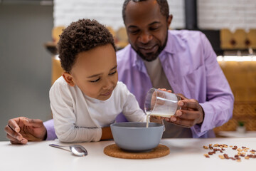Father and kids having breakfast together in the kitchen