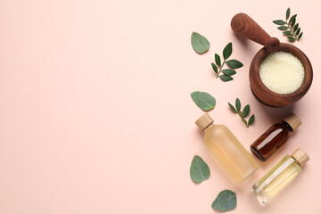 Different cosmetic products and green leaves on beige background, flat lay. Space for text