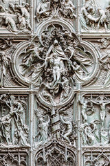 Italy, Milan. Detail of the Cathedral door - the Duomo - with angels and religious symbolic scene. No people.