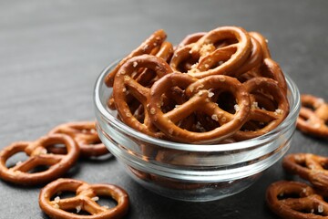 Delicious pretzel crackers on black table, closeup