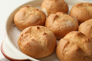 Baking dish with homemade tasty buns on table, closeup