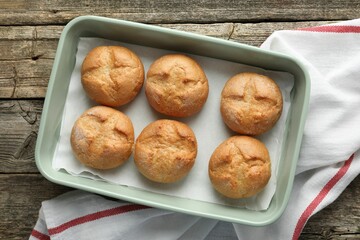 Homemade tasty buns in baking dish on wooden table, top view