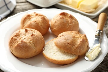 Plate with homemade tasty buns, butter and knife on table, closeup