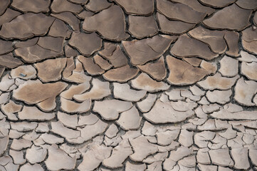 Full frame shot of mudcrack surface and background. Crack formation also occurs in clay-bearing soils as a result of a reduction in water content.