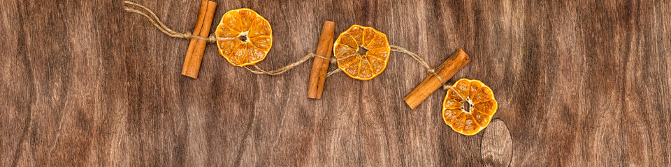 Banner 4x1 Linkedin. Pendant for Christmas with dried orange and cinnamon. Wooden background