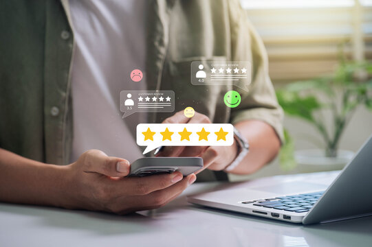 Customer Satisfaction, Digital interaction concept. person using a smartphone to leave a customer review, featuring various star ratings and feedback emoticons.