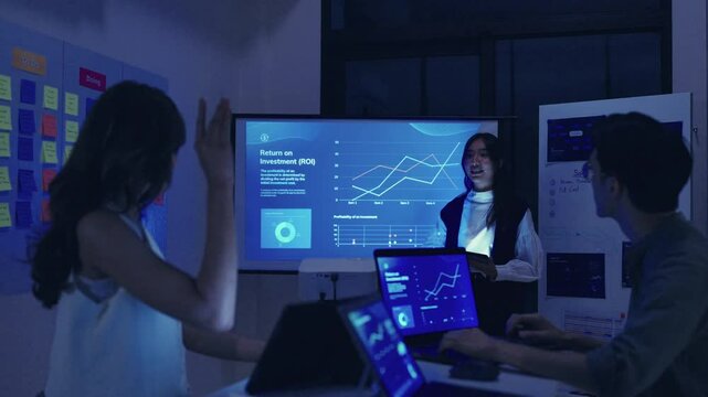 finanical investor asking question when leader reviewing data during a nighttime meeting financial projections and digital reports displayed on a screen