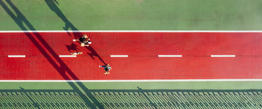 marathon couple athletes and small dog running on red green bridge aerial top view. Active Sport theme. Runners with dog on green and red. Summer morning active couple. Long horizontal banner