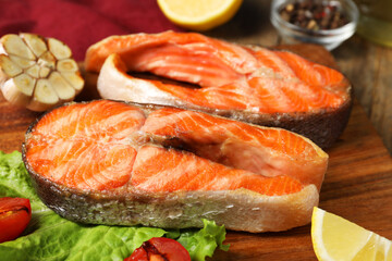 Tasty grilled salmon steaks and products on table, closeup