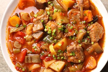Delicious stew with vegetables in bowl on table, top view