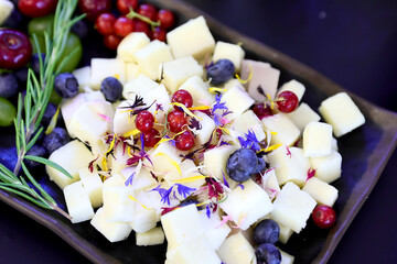 Assorted cheese plate with blueberries and red currants