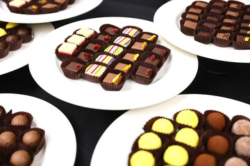 Colored handmade chocolate candies on a plate.
