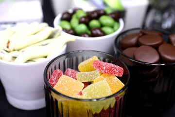 Different assortments of colored jellies on a glass bowl.