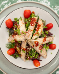 Fresh salad topped with breaded eggplant, sesame seeds and herbs