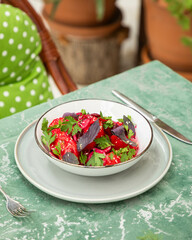 Salad with tomatoes, beetroot and basil on restaurant table