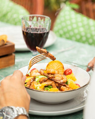 Businessman eating healthy grilled shrimps and orange salad for lunch break