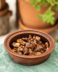 Delicious beef stew with cranberry sauce simmering in earthenware pot