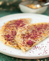 Two traditional flatbreads with spices served on white plate
