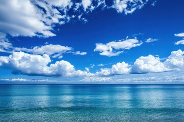 Breathtaking blue ocean accompanied by a bright sky and soft cloud formations in the background