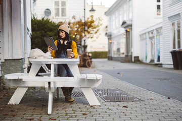 Woman with Coffee Using Tablet at Outdoor Table