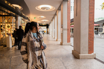 Woman Window Shopping at Outdoor Mall in Winter