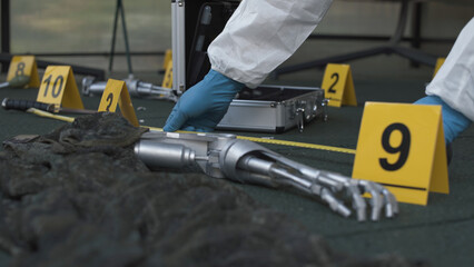 Forensic expert working at fantastic crime scene with evidence like robot hands. Lots of evidence tags, aluminum tool case. Daytime.