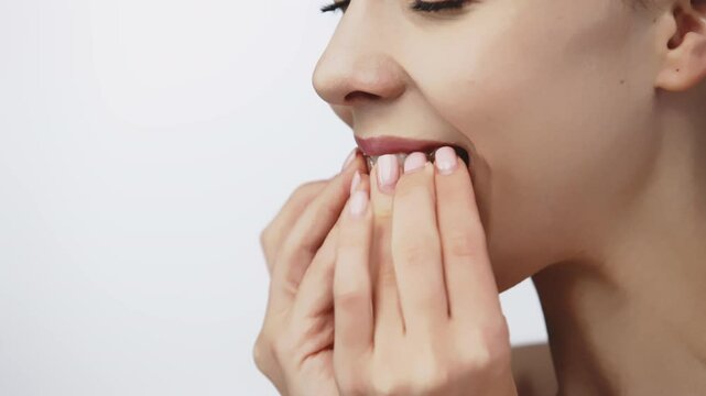 A woman uses an orthodontic silicone trainer for teeth correction. This mobile device highlights modern dental care methods and whitening systems, promoting a healthy and radiant smile.