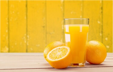 Orange Slices Arranged  with a glass of juice on a wooden table HD Photograph with the vibrant color orange
