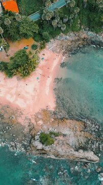 Vertical Video - Aerial view of  rocks and waves on a beach