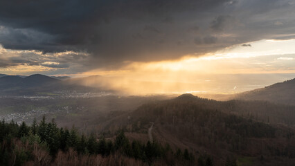 The setting sun brightens up a rain shower over the Murg valley in the northern part of the forest