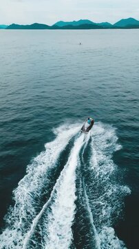Aerial view of  a girl riding water scooter boat