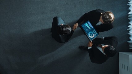 Top down aerial view of skilled businessman shake hands with smart executive manager. Slow motion of team working together to analyze stock investment data from tablet. Making agreement. Directorate.
