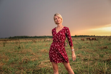 Portrait of a young beautiful blonde girl in a dress in nature.