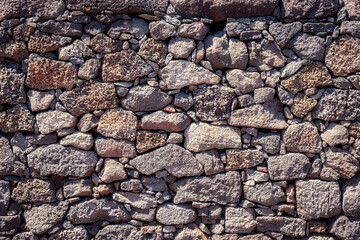 Detail view of textured structured wall build from volcanic rock