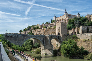 View of the Alcantara bridge with the Alcazar in the background in Toledo. Spain