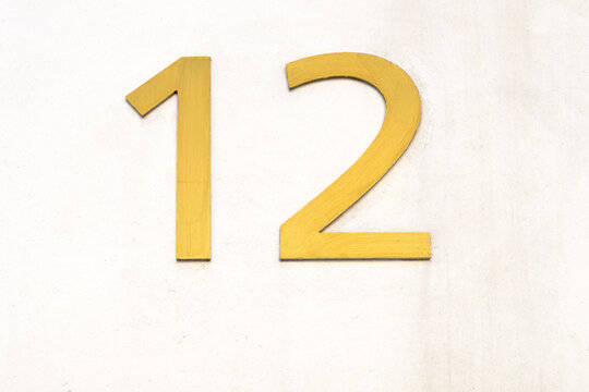 Number twelve in gold color on white background