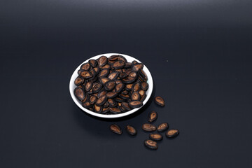 Watermelon seeds roasted on a black background, close-up. Asian appetizer