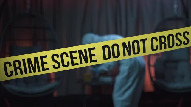 Police tape at a crime scene with a forensic expert working in the background. 