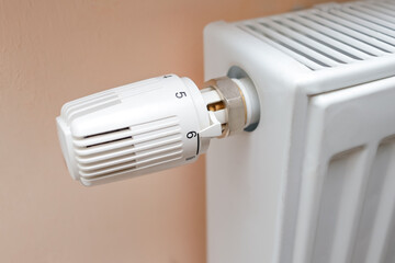 Temperature control knob on room battery. Metal radiator with individual control. heating system, energy crisis, energy saving, heat saving, heating season