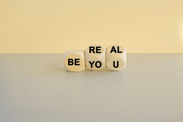 Motivational quote Be real, be you on wooden cubes against beautiful beige background. Gray table. Business and lifestyle concept.