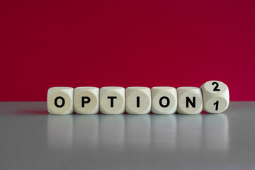 Wooden cubes with Option 1 sign going to Option 2. Beautiful grey table, red background. Concept of Change, Choice and Strategy.